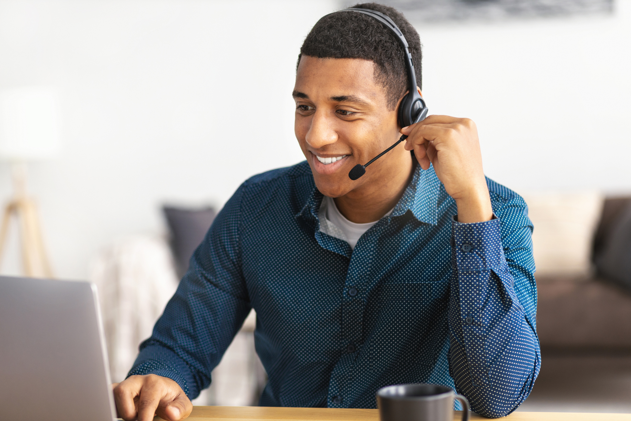 Customer service representative from a medical billing company wearing a headset and working on a laptop, supporting gastroenterology practices with patient billing and administrative assistance.