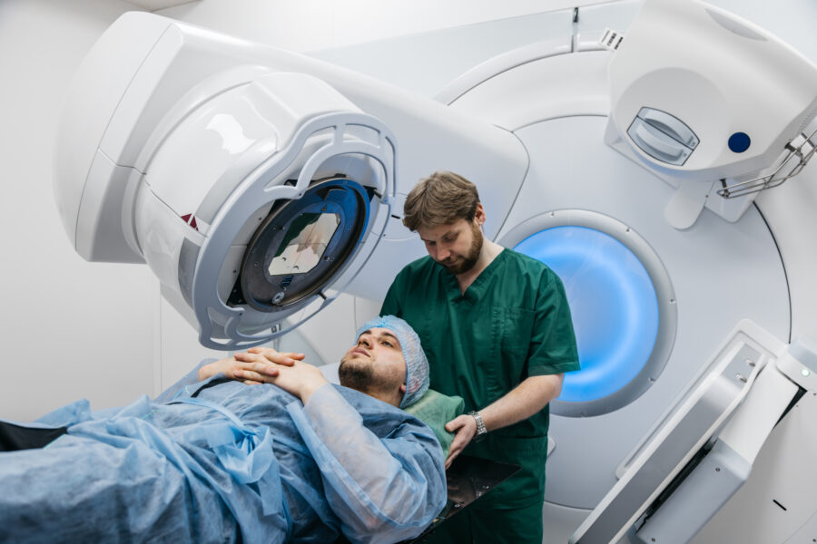 Radiation therapist positioning a cancer patient under a linear accelerator for radiation therapy treatment