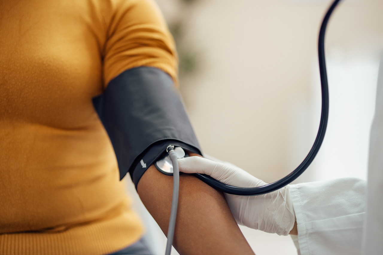 Close-up of a healthcare provider checking a patient's blood pressure during a primary care visit.
