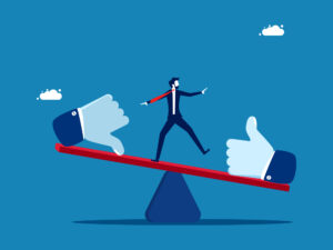 Illustration of a businessperson balancing on a seesaw with a thumbs-down icon on one side and a thumbs-up icon on the other, representing weighing pros and cons or making a difficult decision.