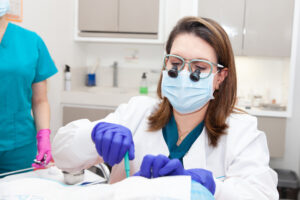 Dermatologist performing facial skin biopsy on senior patient during skin lesion removal procedure in a medical clinic — dermatology treatment and minor surgical care.