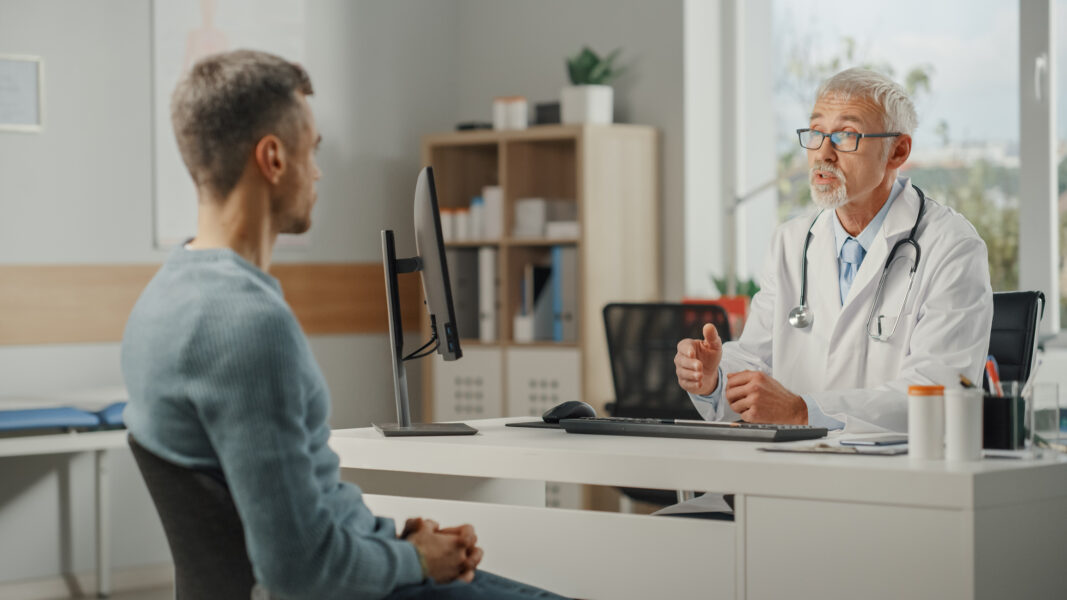 Urologist speaking with a male patient during a consultation in a medical office